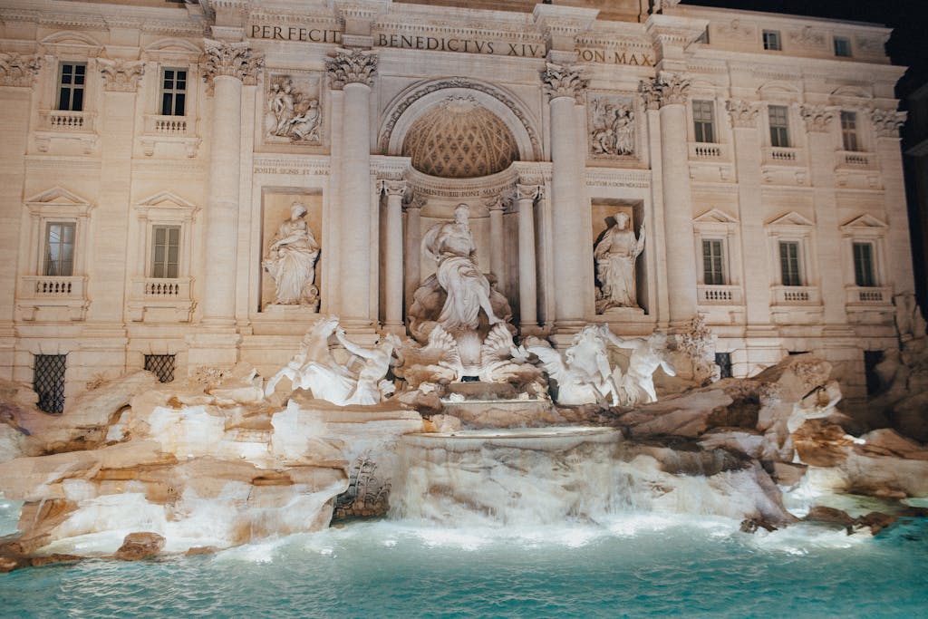 Captivating nighttime shot of the iconic Trevi Fountain in Rome, Italy, showcasing its intricate sculptures and architecture.